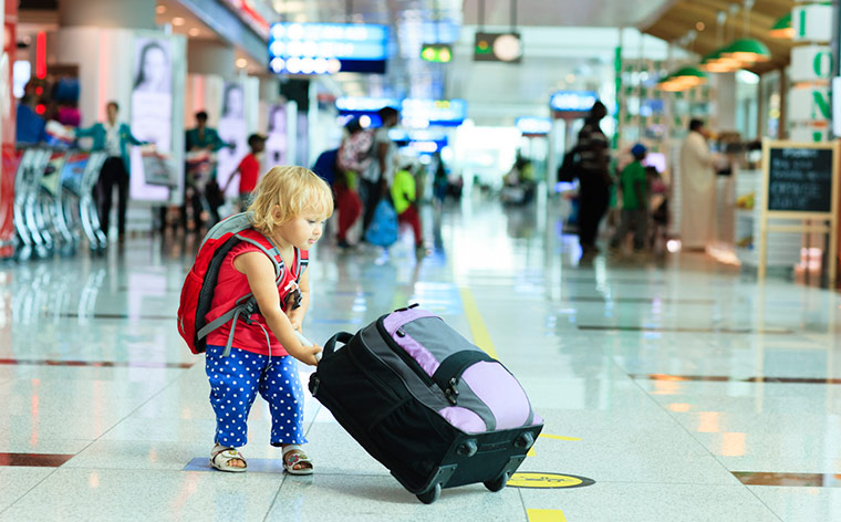 A kid pulling her suitcase at the Airport.