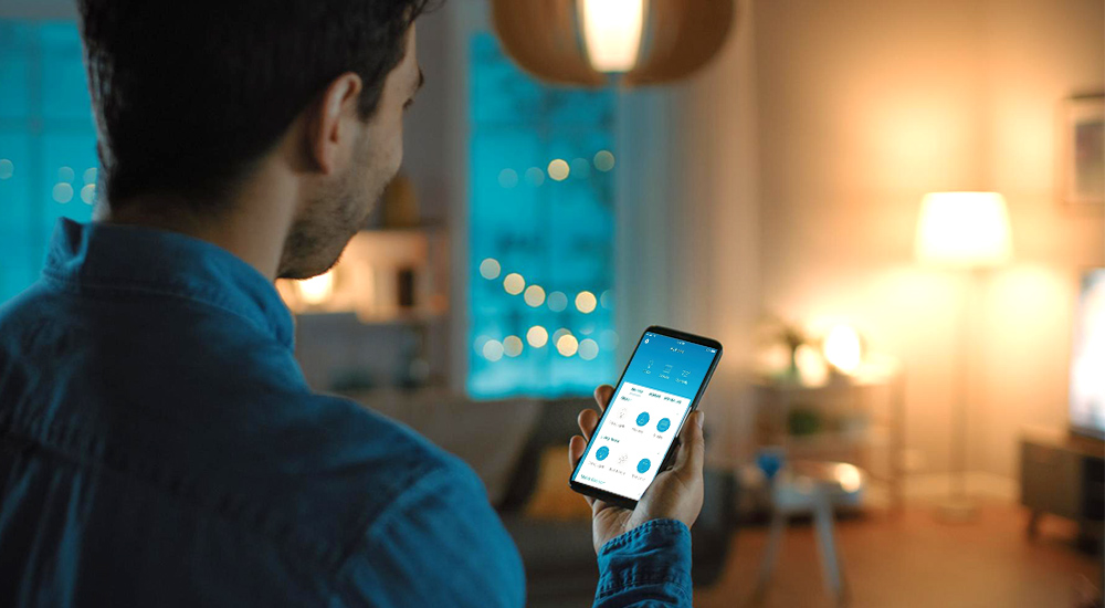 A guy controlling smart appliances from his phone.