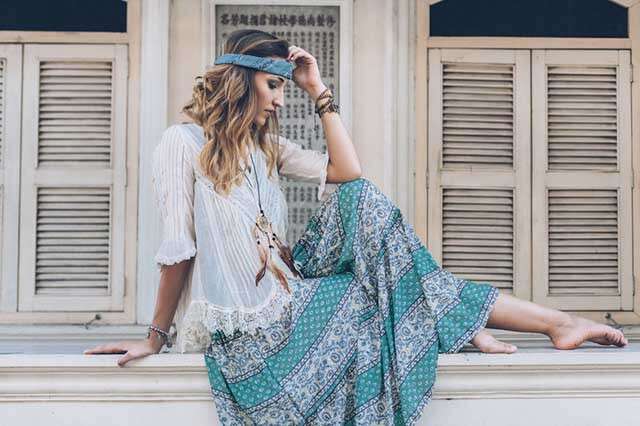 A girl posing for camera in a bohemian outfit.